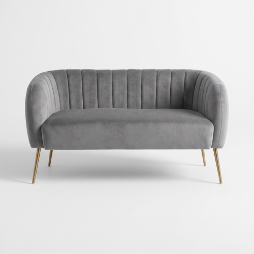 Gray velvet sofa with curved back and vertical channel tufting, supported by slim gold legs on a white backdrop.